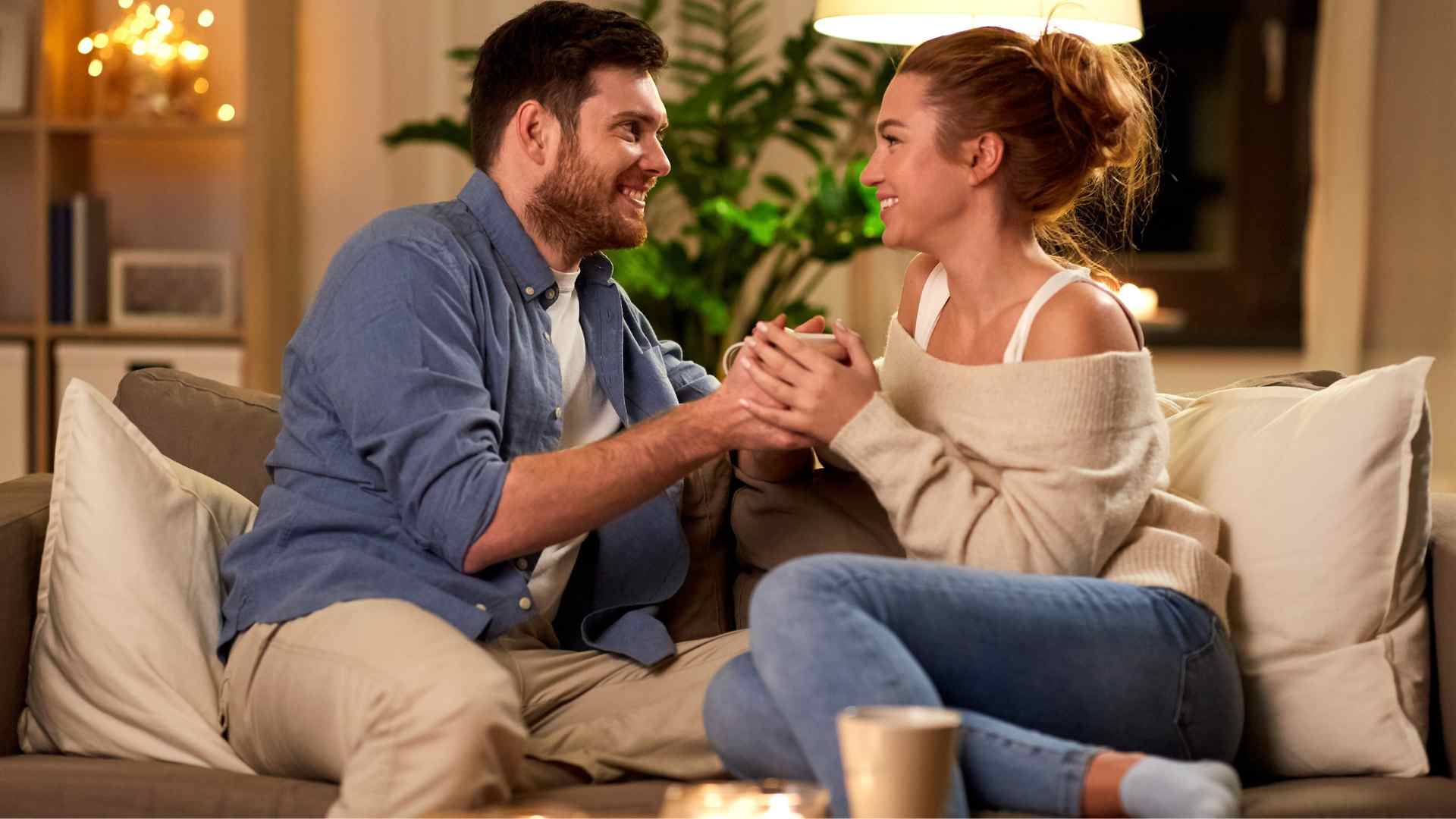 Couple souriant sur un canapé, illustrant des étapes clés pour trouver une copine